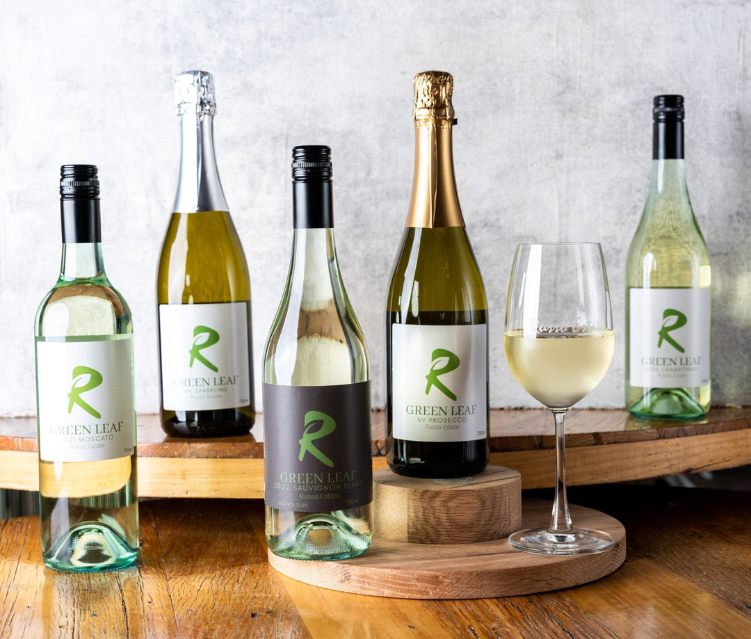 white wines on a table, pinot grigio, moscato, chardonnay, sparkling wine, sauvignon blanc, front facing